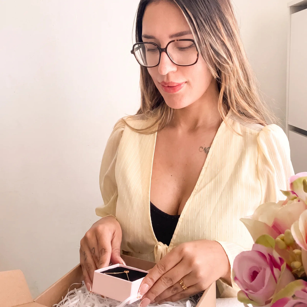 Vanessa colocando una joya en su caja rosa antes de preparar el pedido.